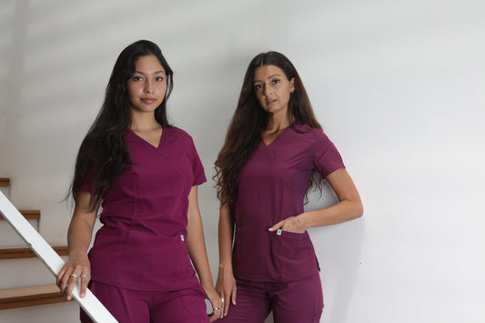 2 profesionales usando trajes clínicos de mujer en color burdeo