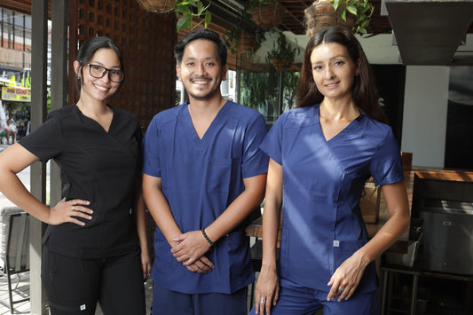 profesionales usando uniformes clínicos negro y azul