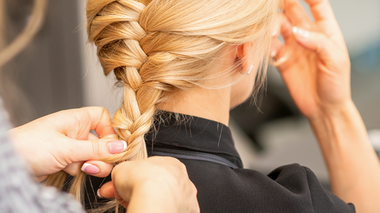mujer trenzando el cabello de otra mujer