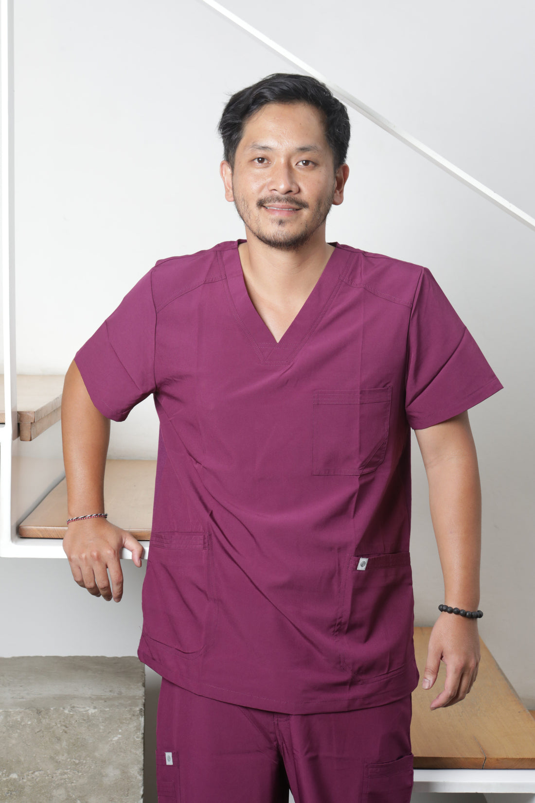 Profesional de la salud vistiendo un uniformes clínico antifluidos en color burdeo para hombre