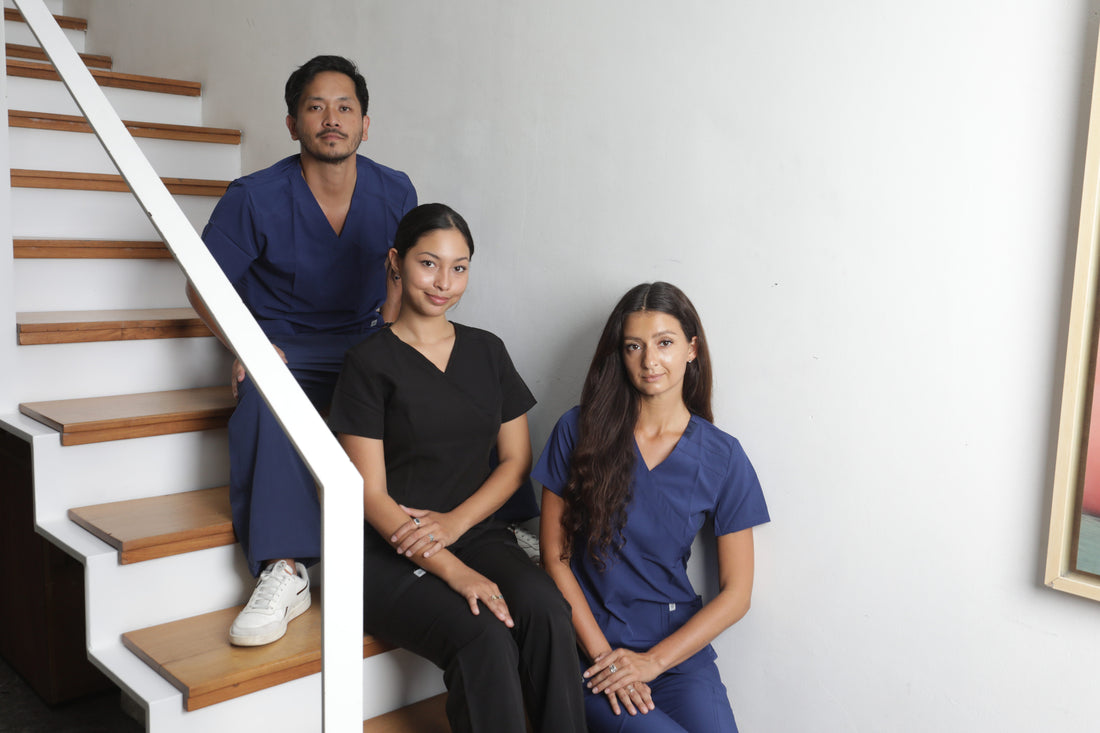 tres profesionales de la salud usando uniformes clínicos en color azul y negro