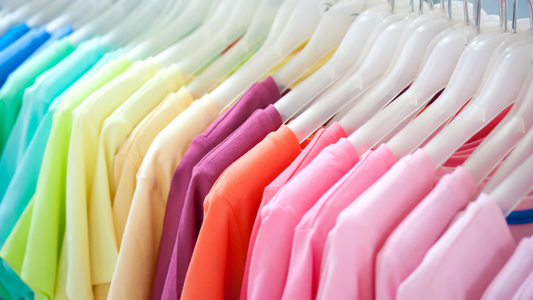 uniformes clínicos de variados colores guindados en perchas