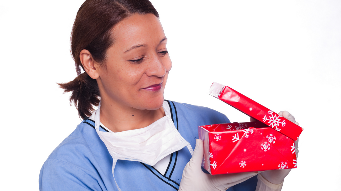 profesional de la salud usando un uniforme clínico y abriendo un regalo