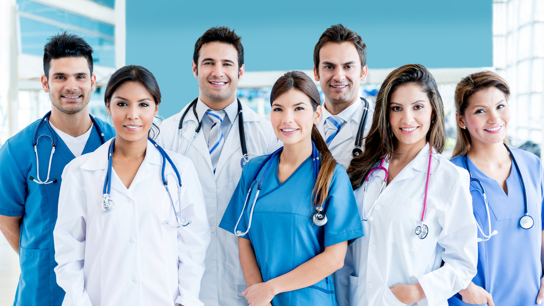 profesionales de la salud con uniformes clínicos azul y blanco